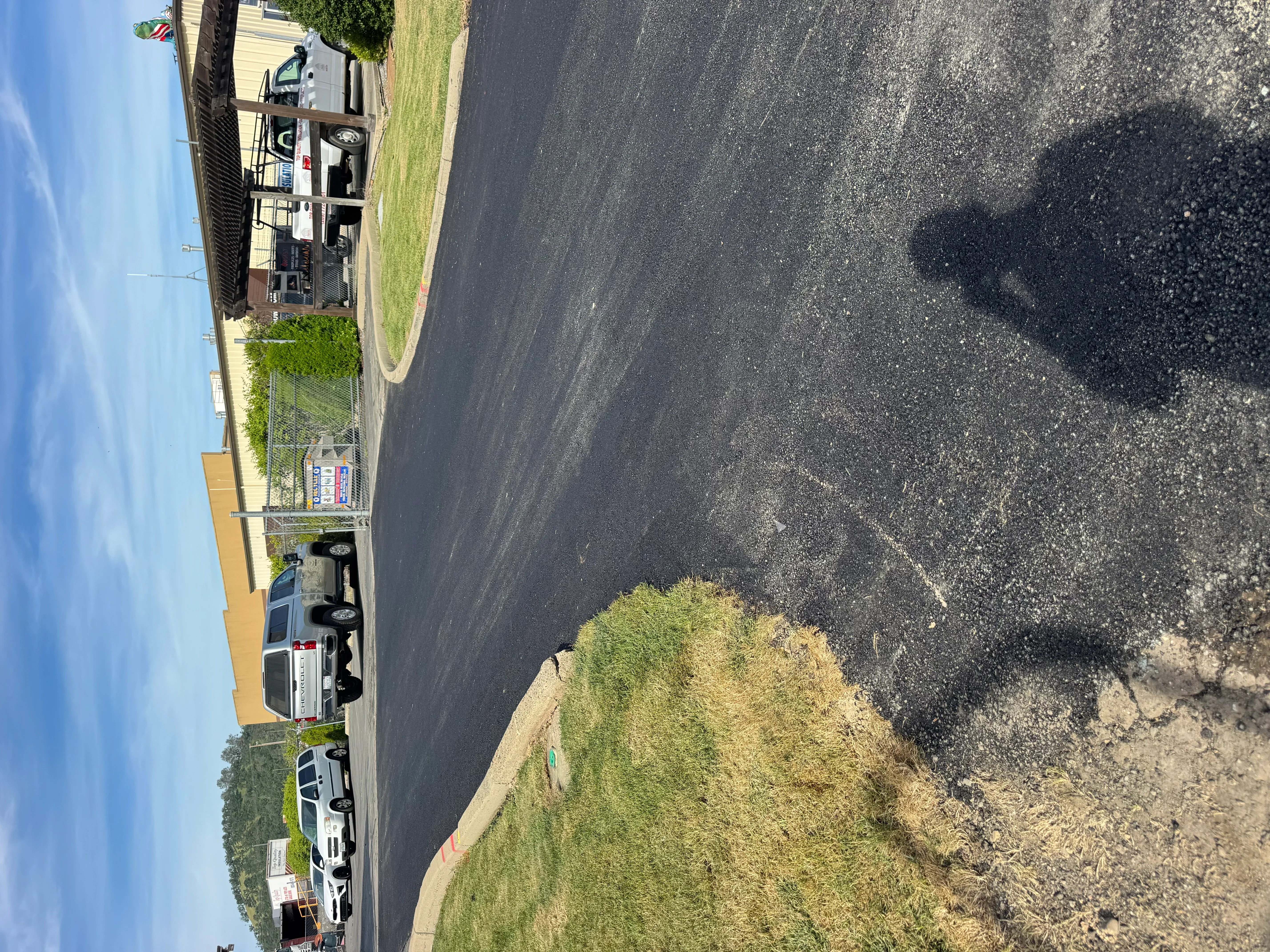 Newly paved residential driveway with dark asphalt and concrete edges